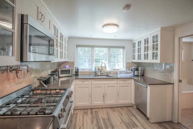 a kitchen with sink stove and refrigerator