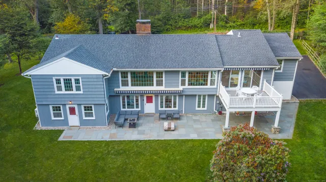 a aerial view of a house with a yard table and chairs
