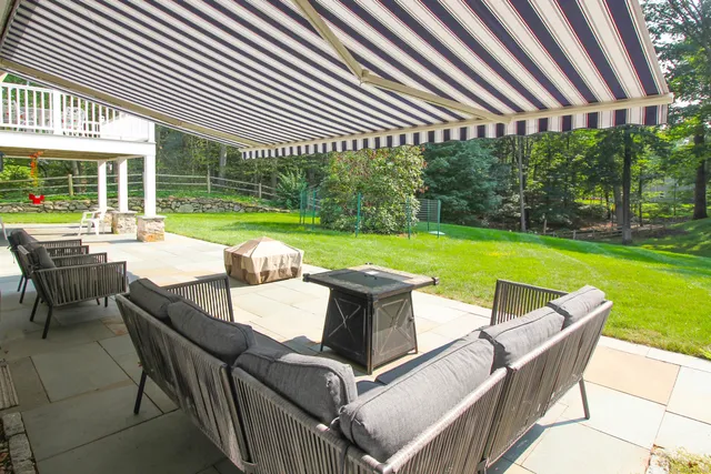 a view of a patio with table and chairs and a barbeque