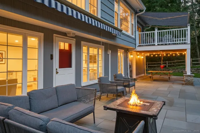 a view of a patio with couches table and chairs and potted plants