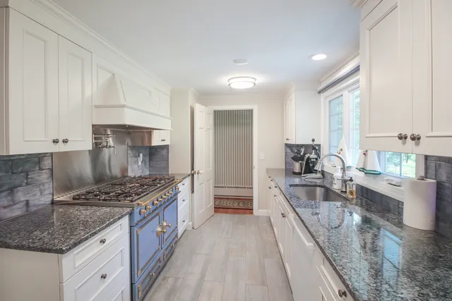 a kitchen with stainless steel appliances kitchen island granite countertop a sink stove and refrigerator
