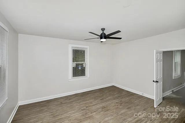 a view of a room with wooden floor and windows