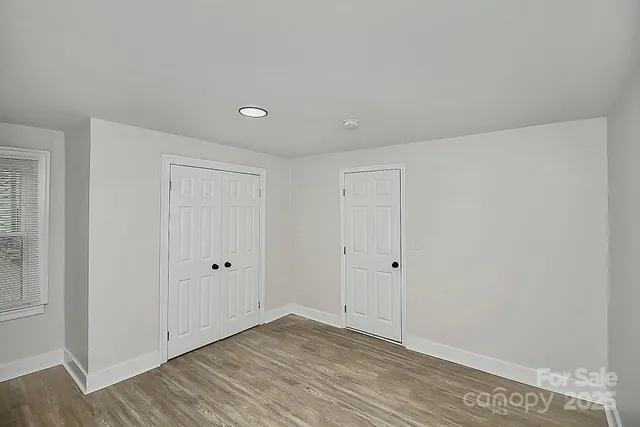 a view of an empty room with wooden floor
