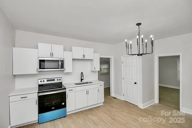 a kitchen with stainless steel appliances a white stove top oven and cabinets