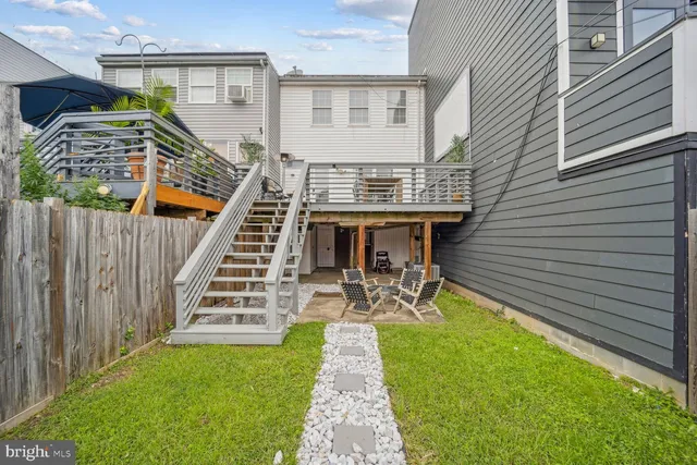a view of a patio with table and chairs with wooden floor and fence