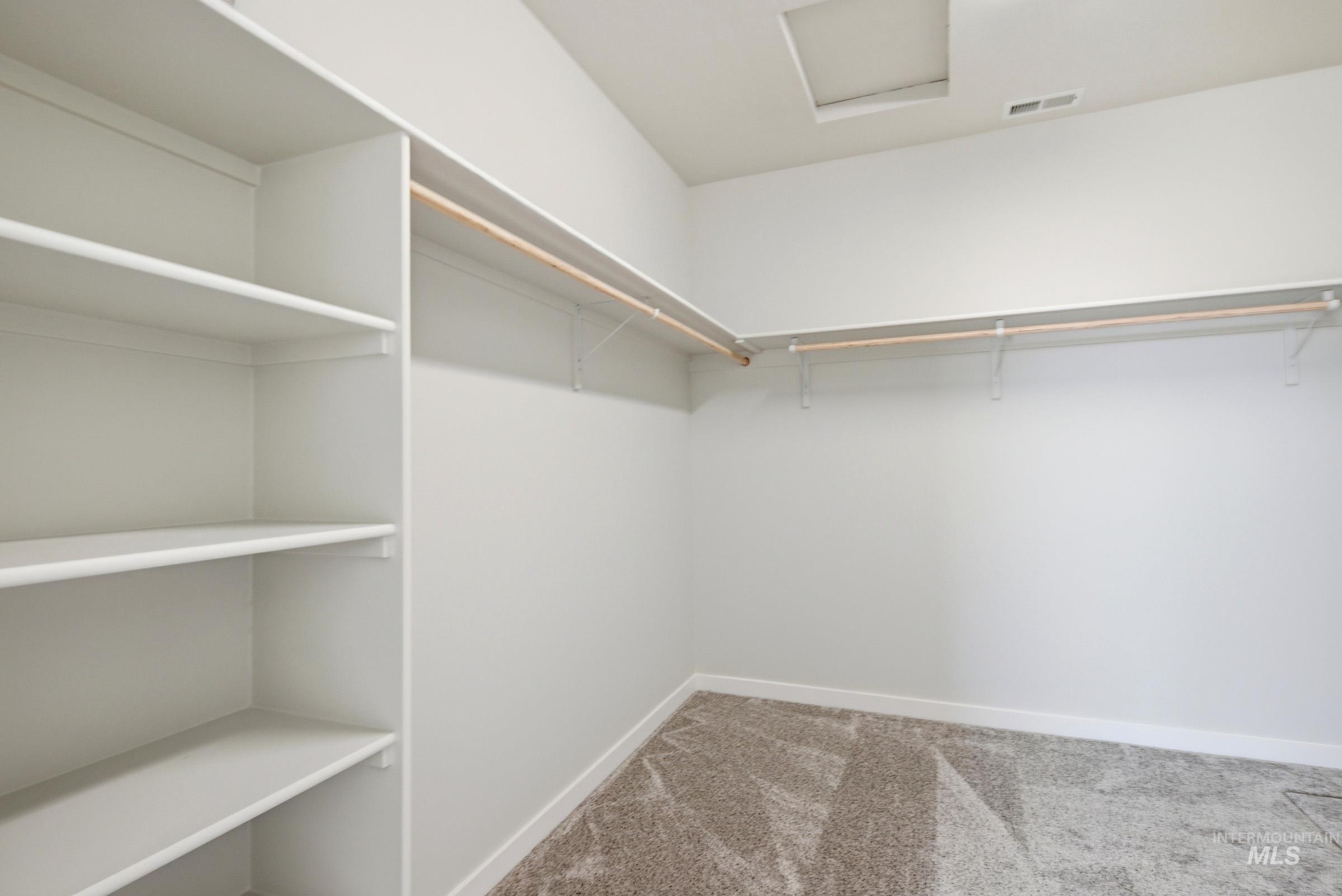 13649 Inman Court Caldwell, ID 83607 - Photo 20 of 22 Spacious closet featuring built-in shelving, two clothing rods, and textured carpet flooring