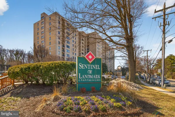 a sign board with buildings in the background