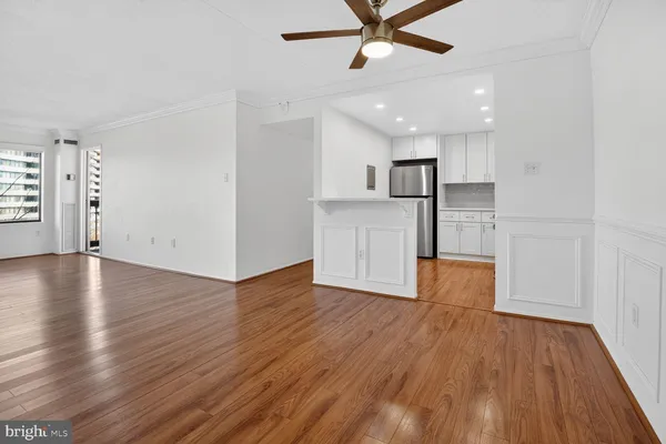 a view of empty room with wooden floor and window
