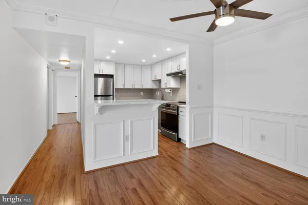 a kitchen with wooden floors and white cabinets