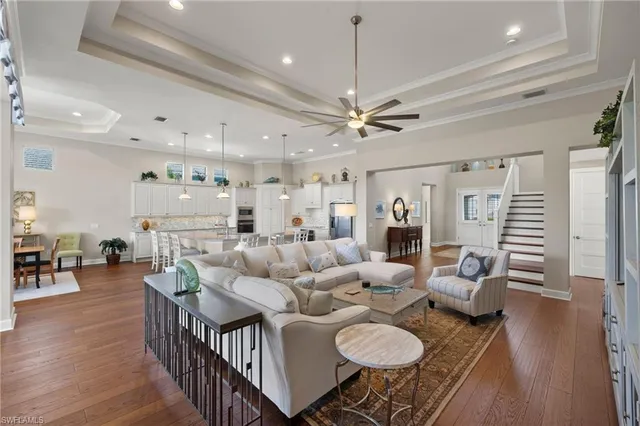 a living room with furniture kitchen view and a chandelier