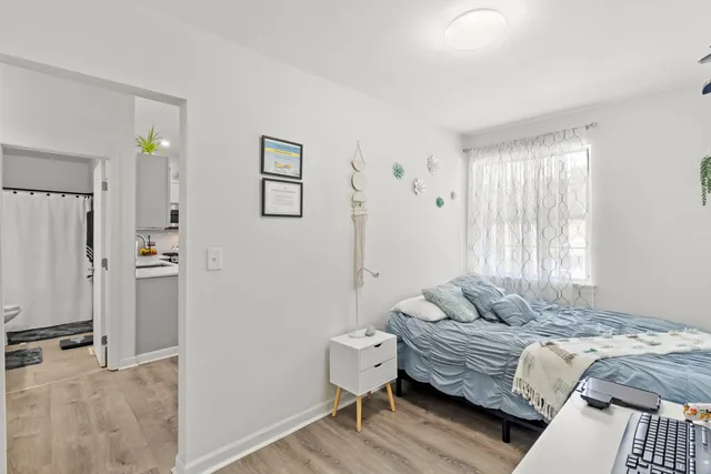 a bedroom with a bed and wooden floor