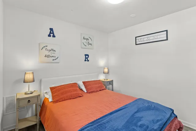 a bedroom with a bed and painting on the wall