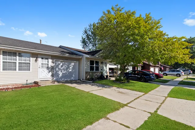a front view of a house with a yard and trees