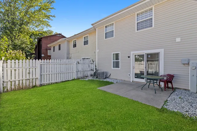a view of a backyard with table and chairs and wooden fence