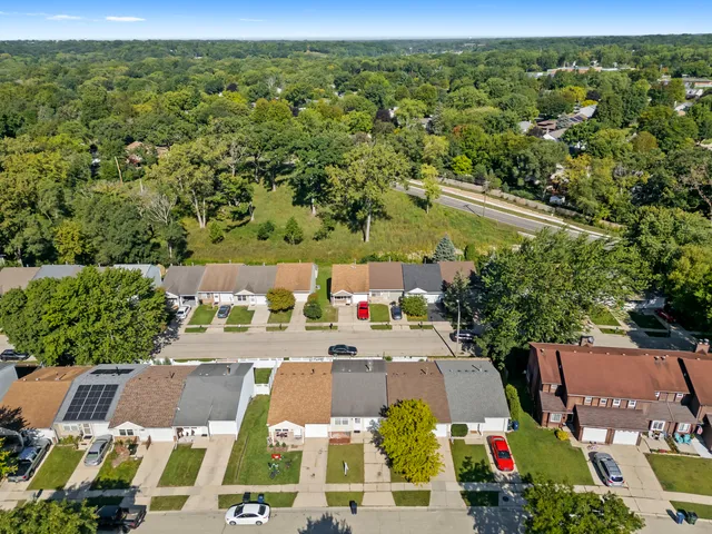 an aerial view of residential houses with outdoor space and street view