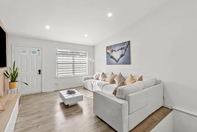 a living room with furniture and wooden floor