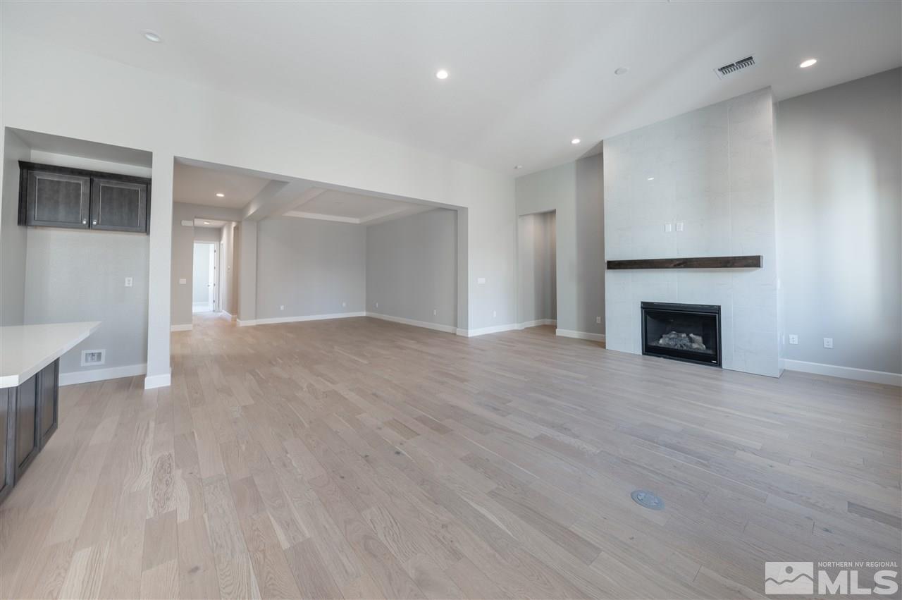 9465 Flying Horse Road, Unit HOMESITE 117 Reno, NV 89521 - Photo 9 of 23 a view of empty room with wooden floor and fireplace