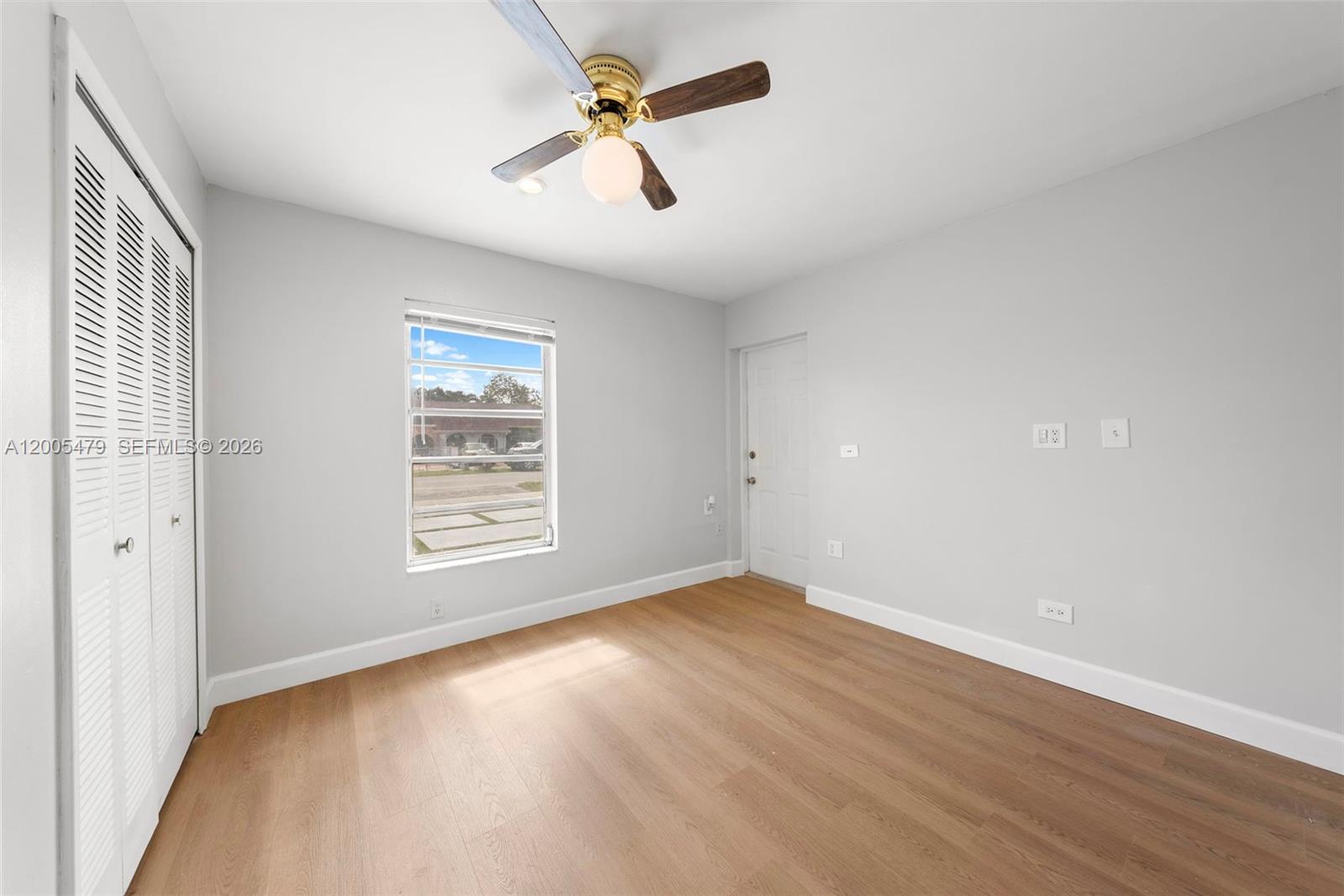 31 Northwest 108th Court, Unit E Miami, FL 33172 - Photo 4 of 5 wooden floor in an empty room with a window