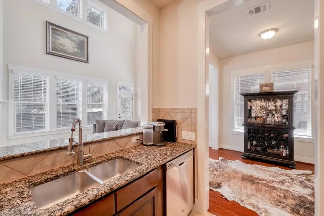 a kitchen with granite countertop a sink stove and cabinets