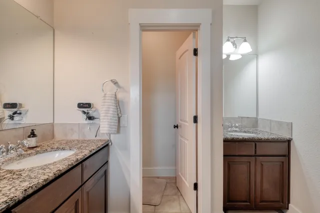 a bathroom with a granite countertop sink and a mirror
