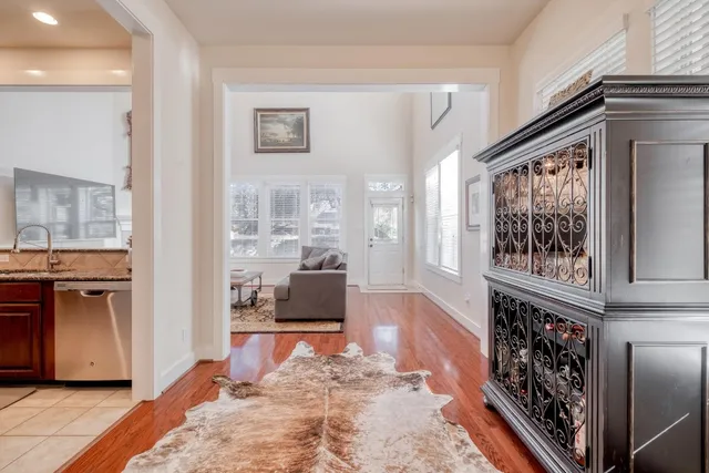 a living room with furniture large window and wooden floor