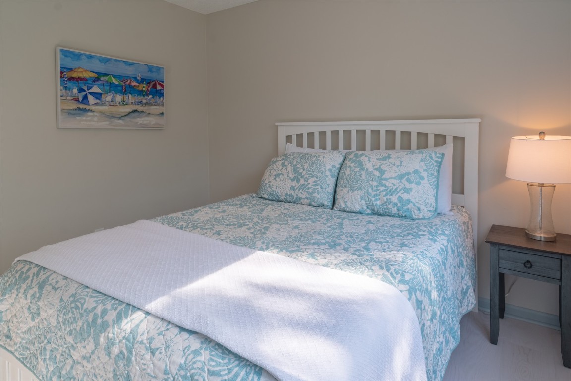 2582 Forest Ridge Drive, Unit N2 Fernandina Beach, FL 32034 - Photo 12 of 30 a bedroom with a bed and a lamp on dresser