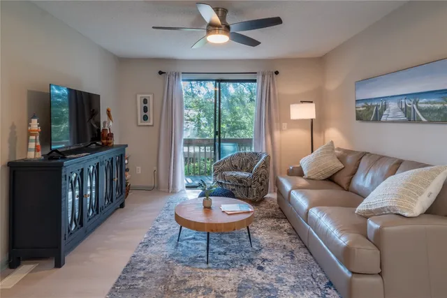 a living room with furniture a flat screen tv and a rug