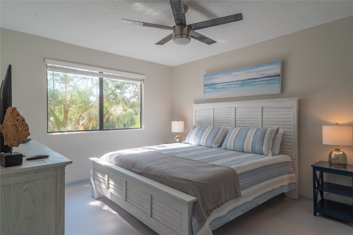 2582 Forest Ridge Drive, Unit N2 Fernandina Beach, FL 32034 - Photo 26 of 30 a bedroom with a bed and a chandelier