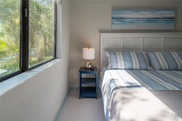 a bedroom with a bed and a large window