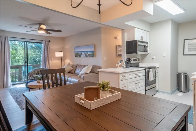 a living room with furniture a flat screen tv and a large window