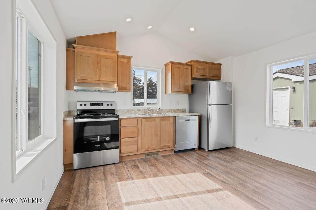 1418 Hathaway Street, Unit 24A Yakima, WA 98902 - Photo 6 of 12 a kitchen with refrigerator a microwave and cabinets