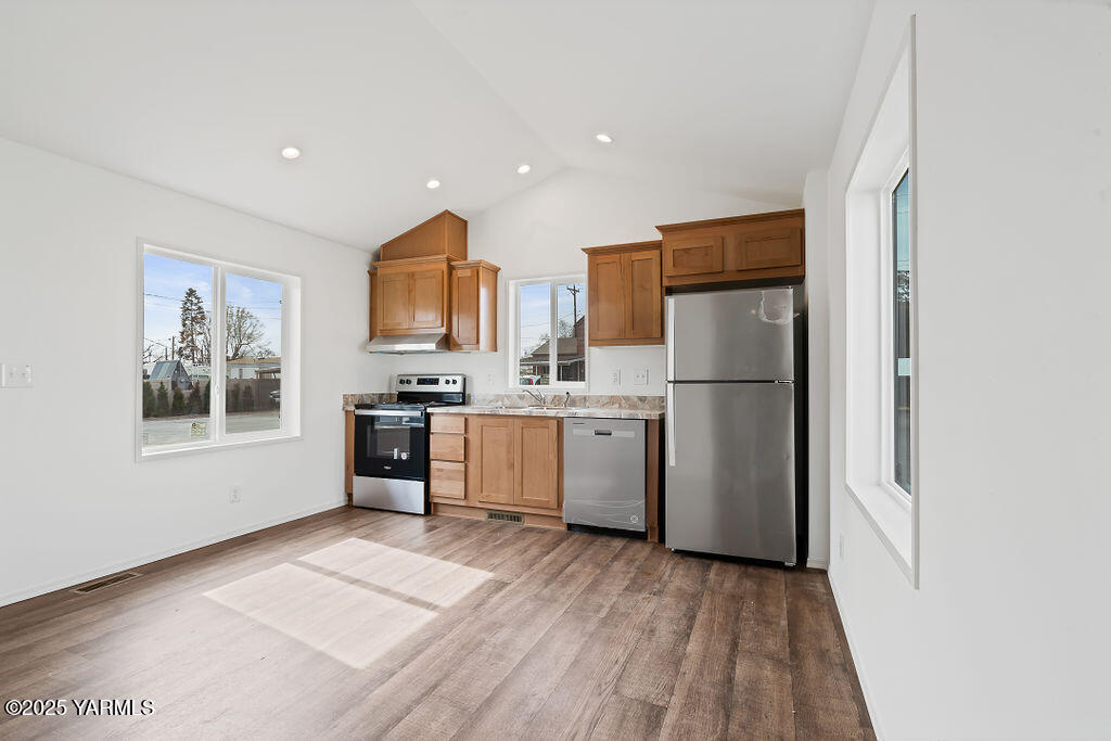 1418 Hathaway Street, Unit 24A Yakima, WA 98902 - Photo 8 of 12 a kitchen with a refrigerator a stove top oven a sink and dishwasher with wooden floor