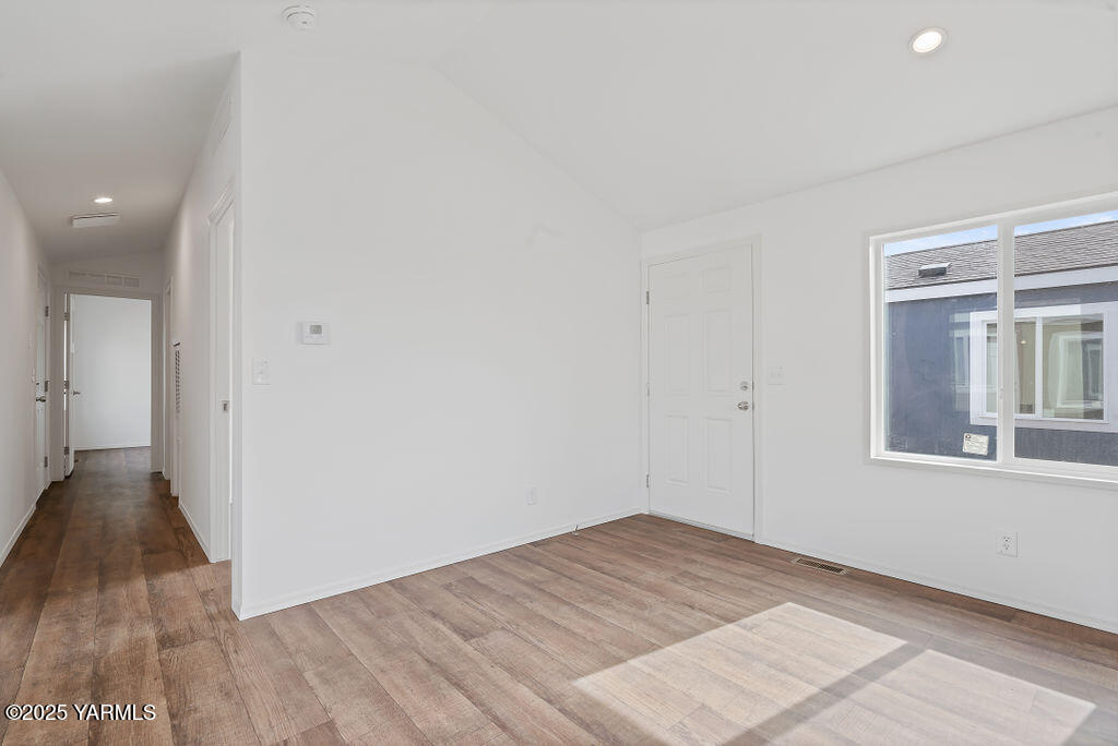 1418 Hathaway Street, Unit 24A Yakima, WA 98902 - Photo 9 of 12 an empty room with wooden floor and windows