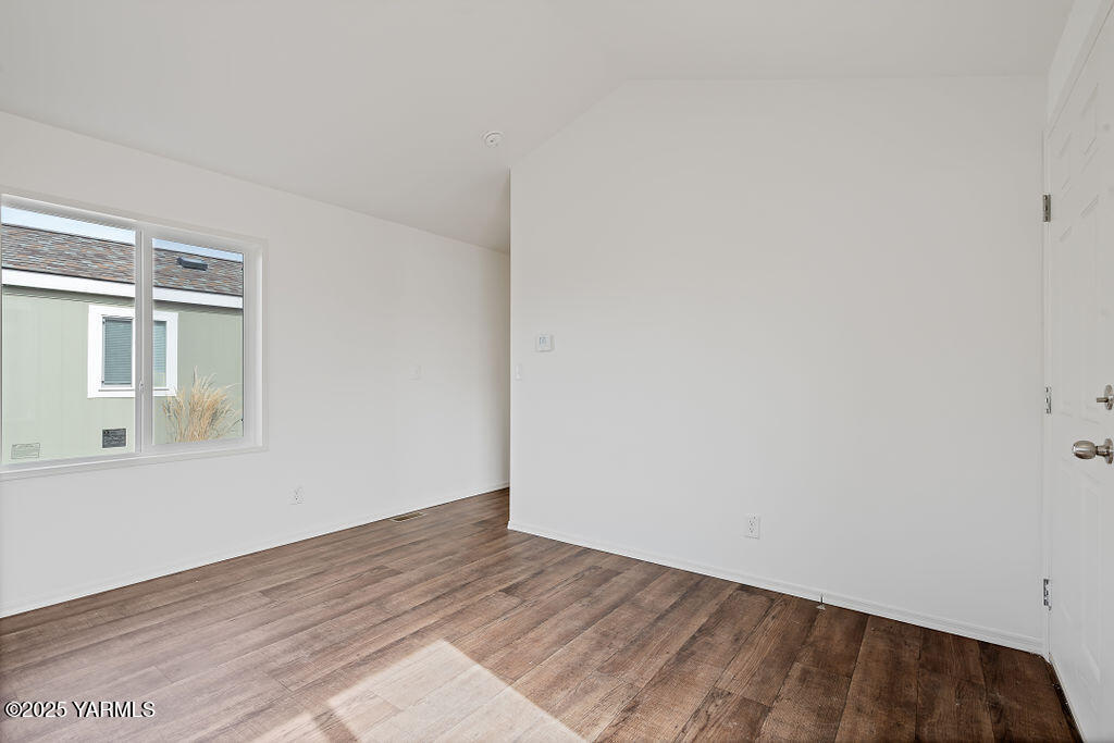 1418 Hathaway Street, Unit 24A Yakima, WA 98902 - Photo 10 of 12 a view of an empty room with wooden floor and a window