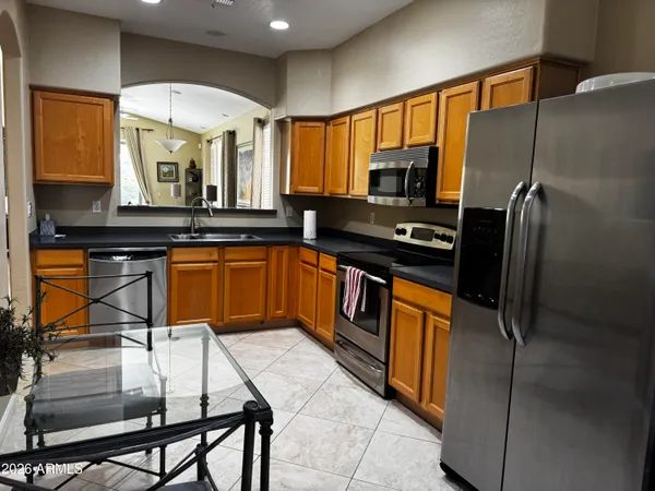 a kitchen with stainless steel appliances granite countertop a sink stove and refrigerator