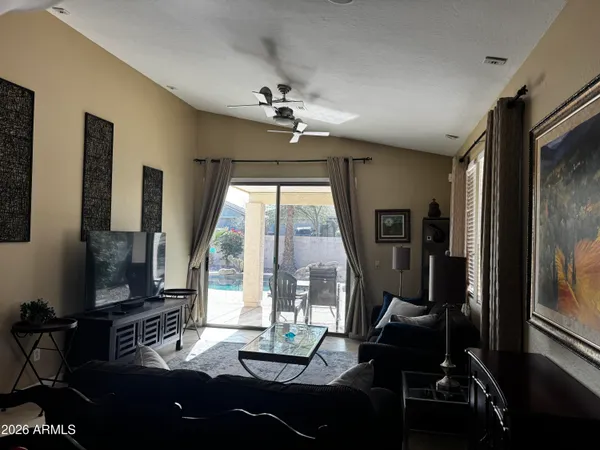 a living room with furniture tv and a floor to ceiling window