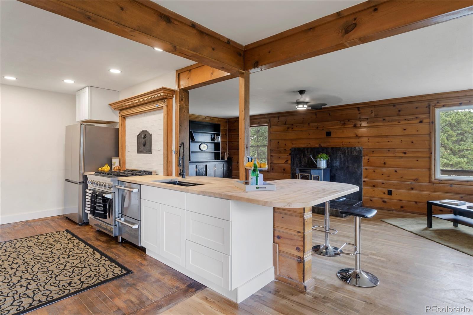 34200 Sioux Trail Pine, CO 80470 - Photo 15 of 37 a living room with stainless steel appliances kitchen island granite countertop furniture and a fireplace