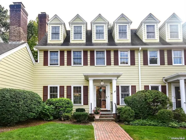 a front view of a house with yard and green space