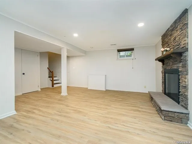 an empty room with wooden floor and fireplace