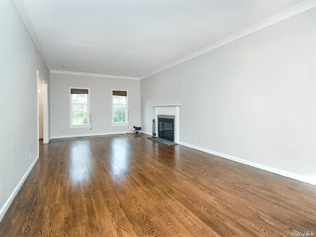 an empty room with wooden floor and fireplace