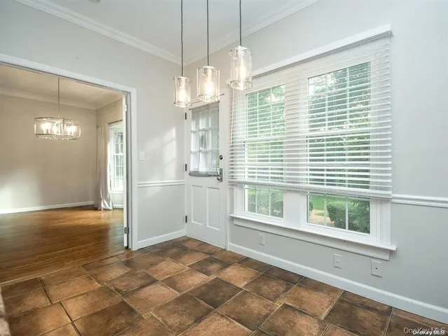 a view of an empty room with a window and chandelier