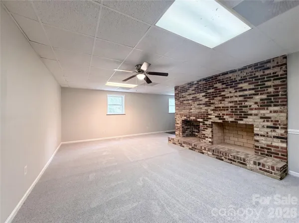 a view of an empty room and chandelier fan