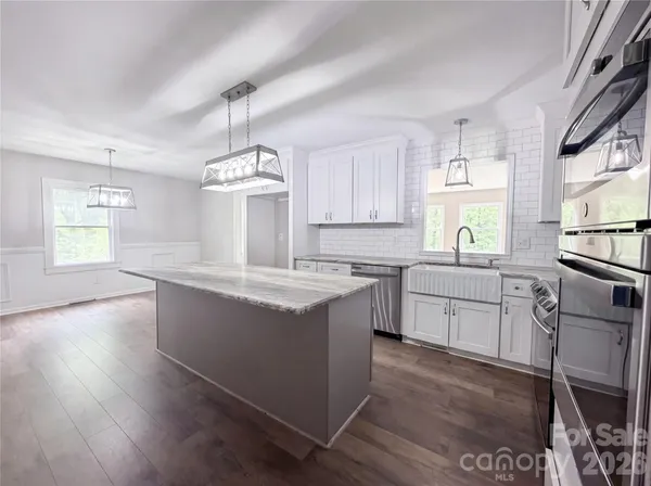 a kitchen with stainless steel appliances granite countertop a sink stove and wooden floor