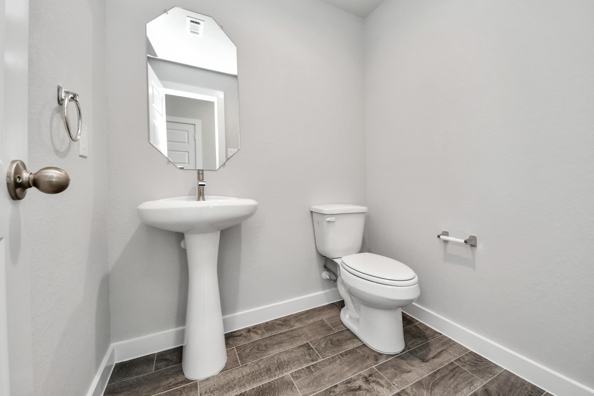 11106 Tulip Rdg Trail Houston, TX 77044 - Photo 4 of 34 This half bathroom features a stylish pedestal sink, modern hardware, and bright recessed lighting, creating a sleek and inviting space. Sample photo of completed home with similar floor plan. Actual colors and selections may vary.