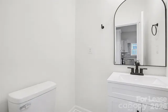 a bathroom with a sink a toilet and mirror