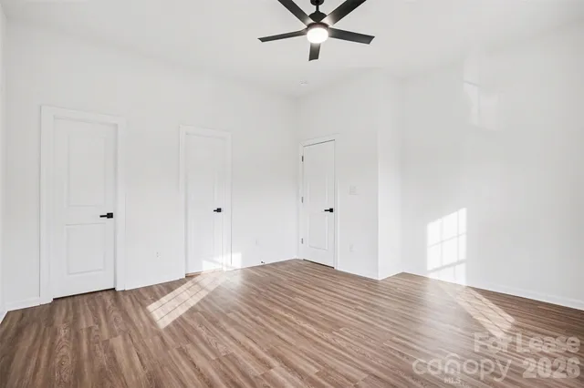 a view of a room with wooden floor and ceiling fan