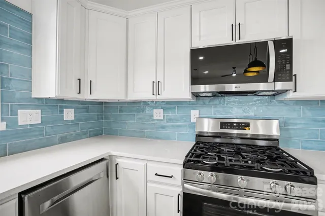 a kitchen with stainless steel appliances a sink and a microwave