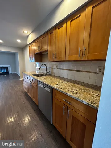 a kitchen with stainless steel appliances granite countertop wooden cabinets a sink and dishwasher