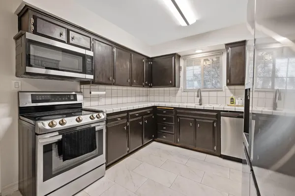 a kitchen with stainless steel appliances granite countertop a stove microwave and sink