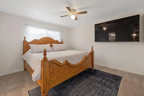 a bed sitting in a bedroom next to a window and a chandelier